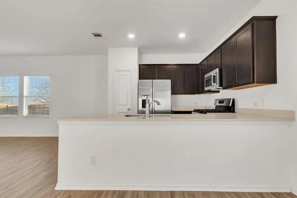 a view of kitchen with stainless steel appliances cabinets
