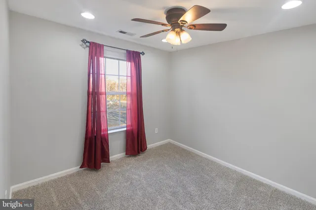 a view of a bedroom with a ceiling fan and a chandelier fan