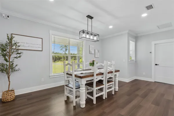 a kitchen with counter space dining table and wooden floor