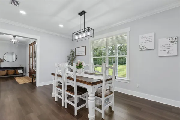 a kitchen with stainless steel appliances white cabinets and a wooden floor