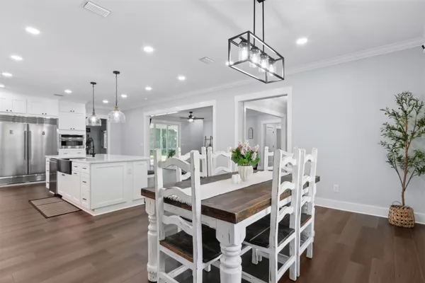 a large kitchen with kitchen island a island a sink a stove and wooden floor
