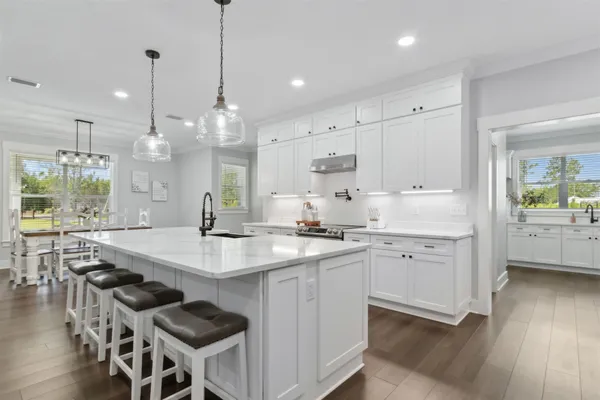 a kitchen with stainless steel appliances kitchen island granite countertop a sink and a refrigerator