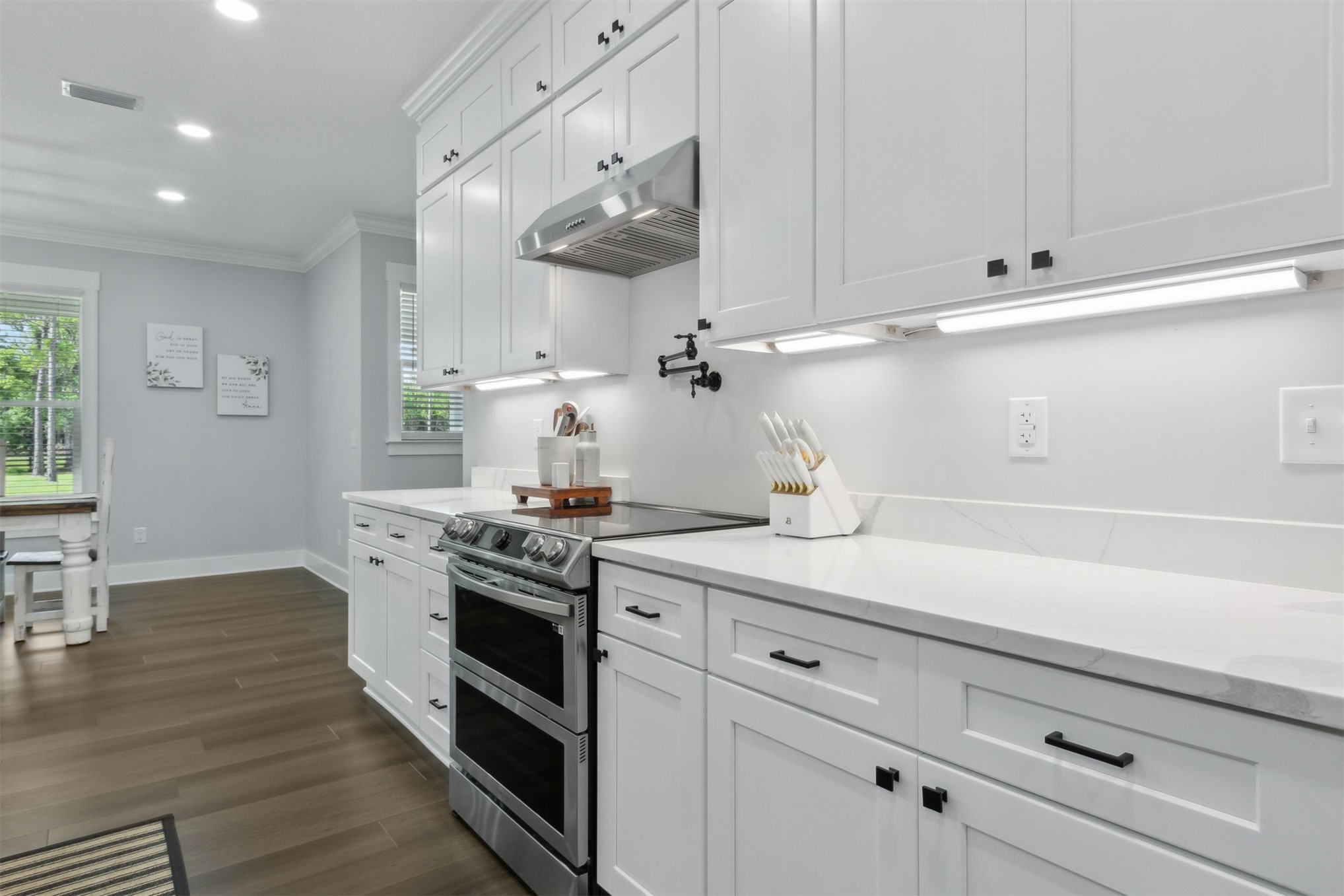 15550 County Road 108 Hilliard, FL 32046 - Photo 21 of 64 a kitchen with stainless steel appliances white cabinets and a wooden floor