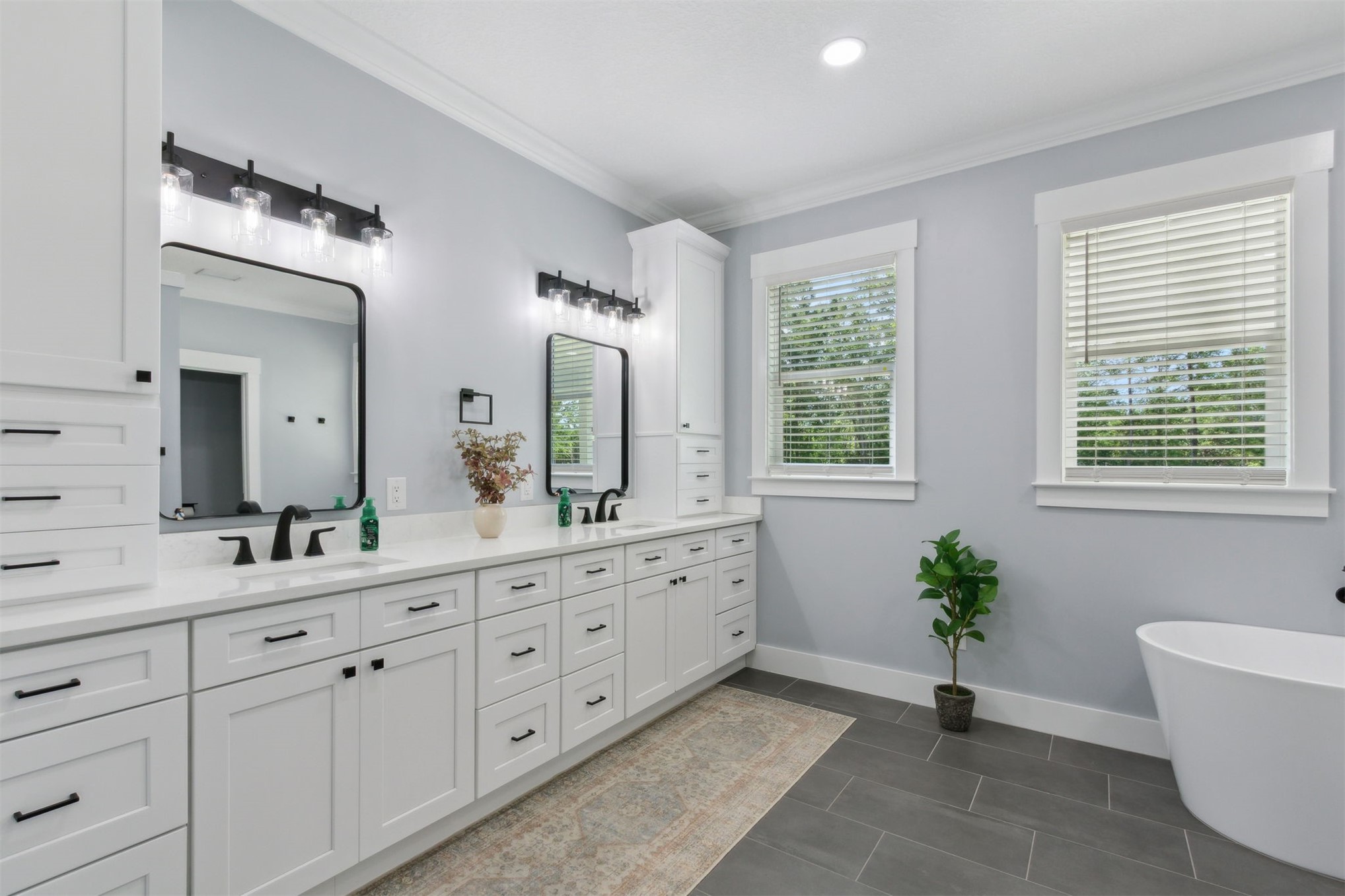 15550 County Road 108 Hilliard, FL 32046 - Photo 36 of 64 a spacious bathroom with double vanity a mirror a bathtub and windows