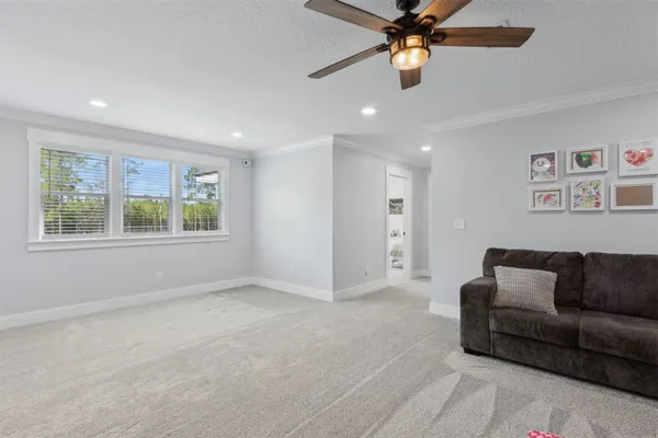 a living room with furniture and a ceiling fan