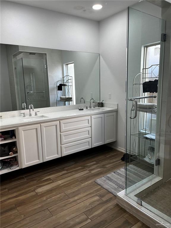 406 Rio Grande Drive Mission, TX 78572 - Photo 14 of 27 Bathroom featuring double vanity, a stall shower, dark wood-type flooring, and recessed lighting
