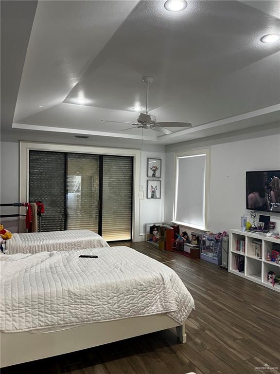 406 Rio Grande Drive Mission, TX 78572 - Photo 18 of 27 Bedroom with dark wood-style floors, a tray ceiling, and a ceiling fan