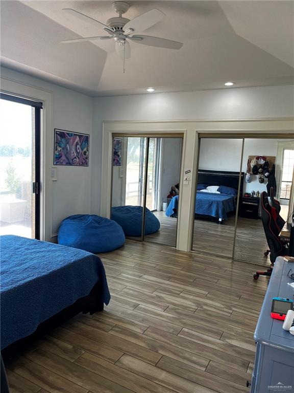 406 Rio Grande Drive Mission, TX 78572 - Photo 21 of 27 Bedroom featuring access to outside, wood finished floors, ceiling fan, two closets, and lofted ceiling