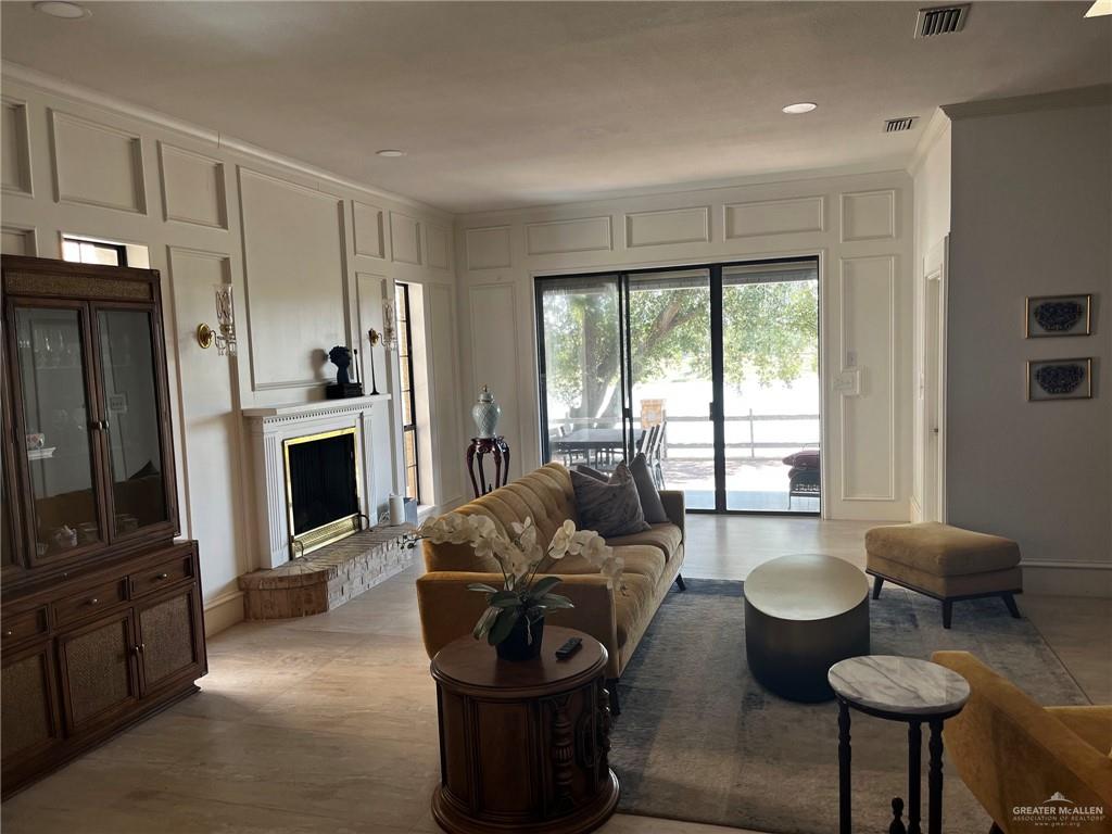 406 Rio Grande Drive Mission, TX 78572 - Photo 10 of 27 Living room featuring a decorative wall, a fireplace, recessed lighting, and crown molding