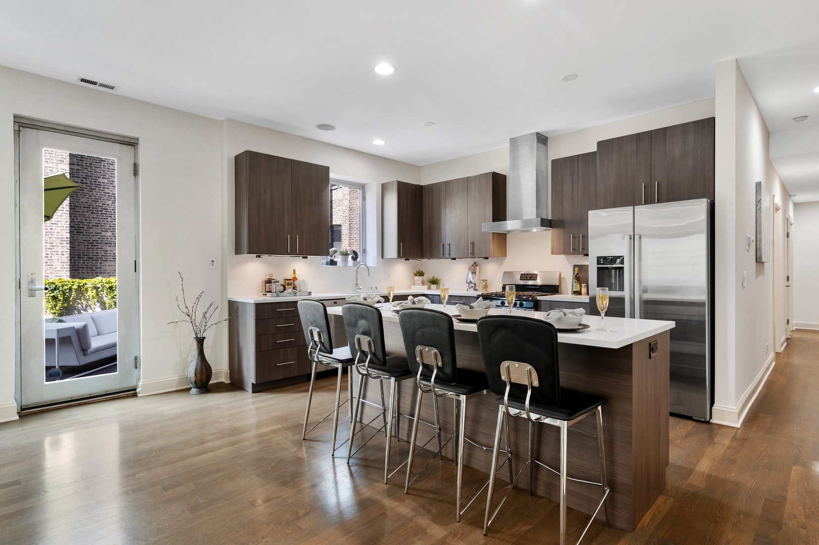 1850 West Division Street, Unit 2E Chicago, IL 60622 - Photo 8 of 22 a kitchen with stainless steel appliances kitchen island granite countertop a table chairs sink and refrigerator