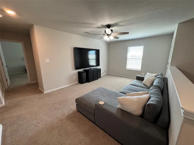 a living room with furniture a flat screen tv and a window
