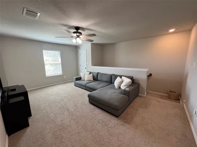 a living room with furniture and a ceiling fan