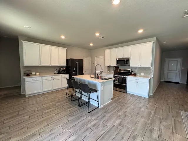 a kitchen with a sink a counter top space stainless steel appliances and cabinets