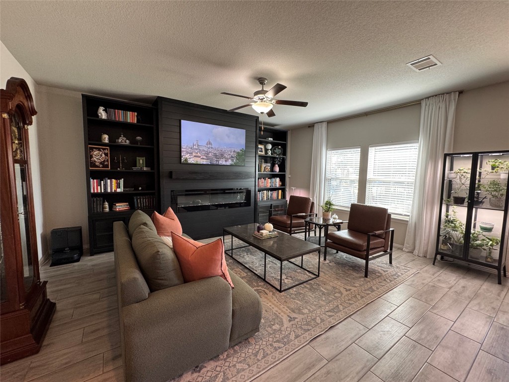 247 Simon Kyle, TX 78640 - Photo 5 of 23 a living room with furniture a ceiling fan and a flat screen tv