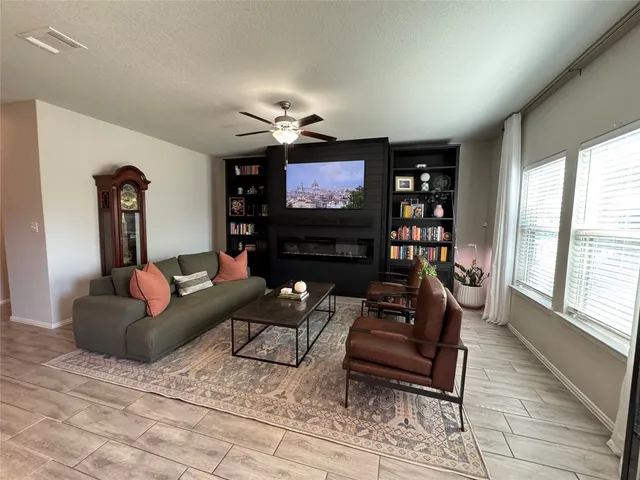 a living room with furniture a large window and a flat screen tv