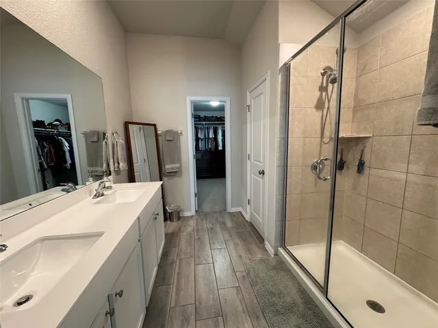 a bathroom with a double vanity sink a mirror and shower