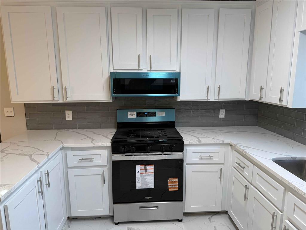2801 Kellogg Creek Road Acworth, GA 30102 - Photo 9 of 28 a kitchen with white cabinets and a stove top oven