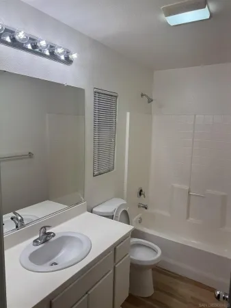 a bathroom with a sink a toilet a mirror and shower