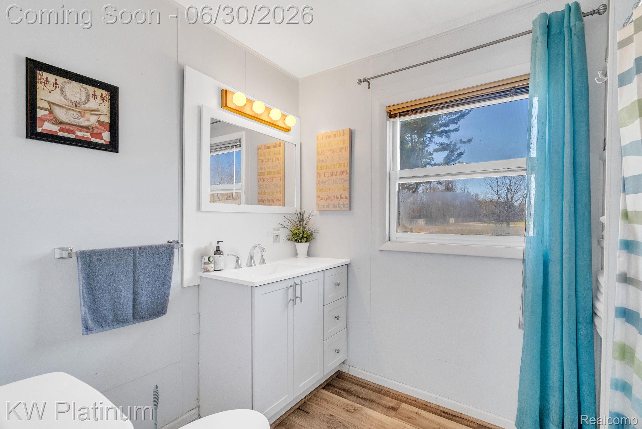 2235 South Lake Shore Road Harbor Beach, MI 48441 - Photo 66 of 99 Bathroom featuring a white vanity with integrated sink, chrome faucet, and a wall-mounted mirror with overhead lighting