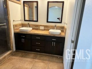 Undisclosed Address Bakersfield, CA 93313 - Photo 13 of 18 a bathroom with a granite countertop sink and a mirror