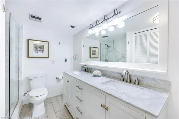 a bathroom with a granite countertop sink mirror vanity and toilet