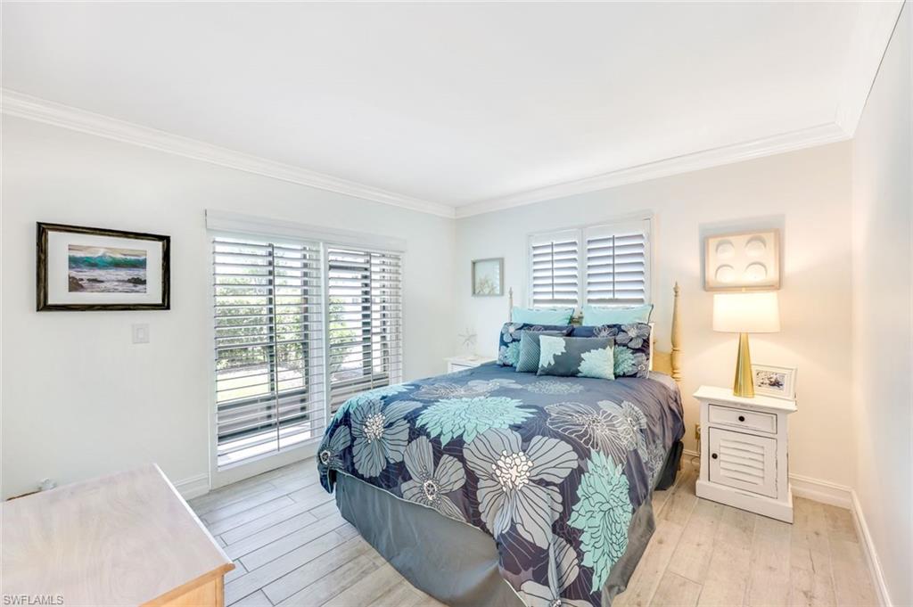 766 Central Avenue, Unit 117 Naples, FL 34102 - Photo 15 of 25 a bedroom with a large bed and a window