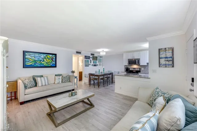 a living room with furniture and a dining table with kitchen view