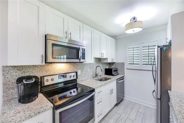 a kitchen with a sink appliances and cabinets
