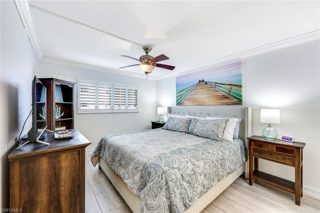 766 Central Avenue, Unit 117 Naples, FL 34102 - Photo 9 of 25 a bedroom with a bed and a night stand