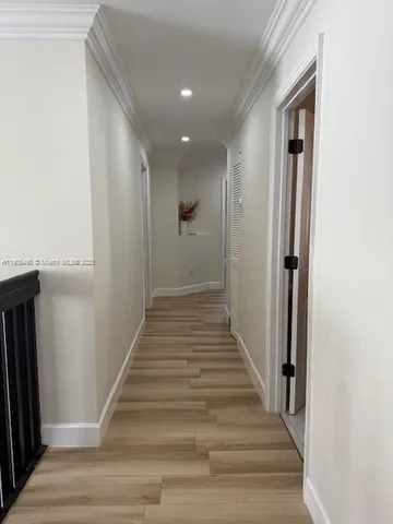 a view of a hallway with wooden floor and entryway
