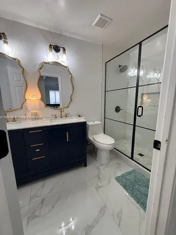 a bathroom with a toilet a sink and mirror
