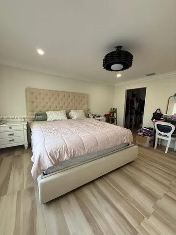 a bedroom with a bed a chandelier and a walk in closet