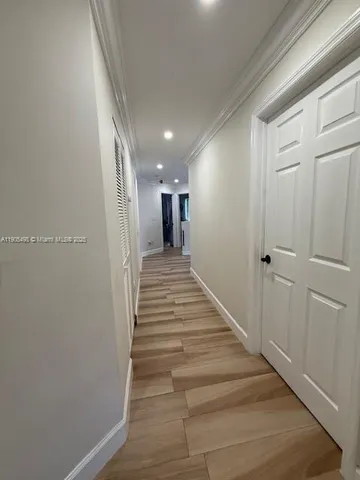 a view of a hallway with wooden floor and entryway