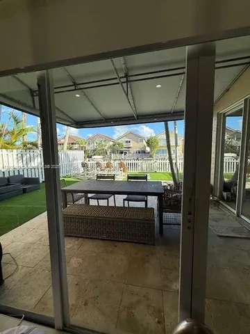 a view of porch with a table and chairs