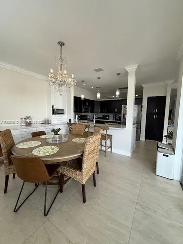 a view of a dining room with furniture and a chandelier