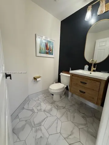 a bathroom with a toilet sink and mirror