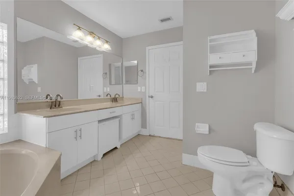 a bathroom with a double vanity sink mirror and toilet