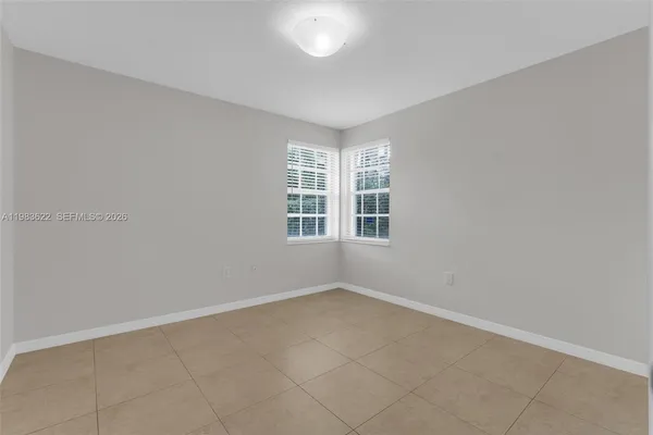 a view of a room with a ceiling fan and refrigerator