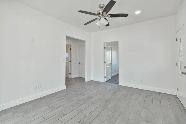 an empty room with fan and entrance