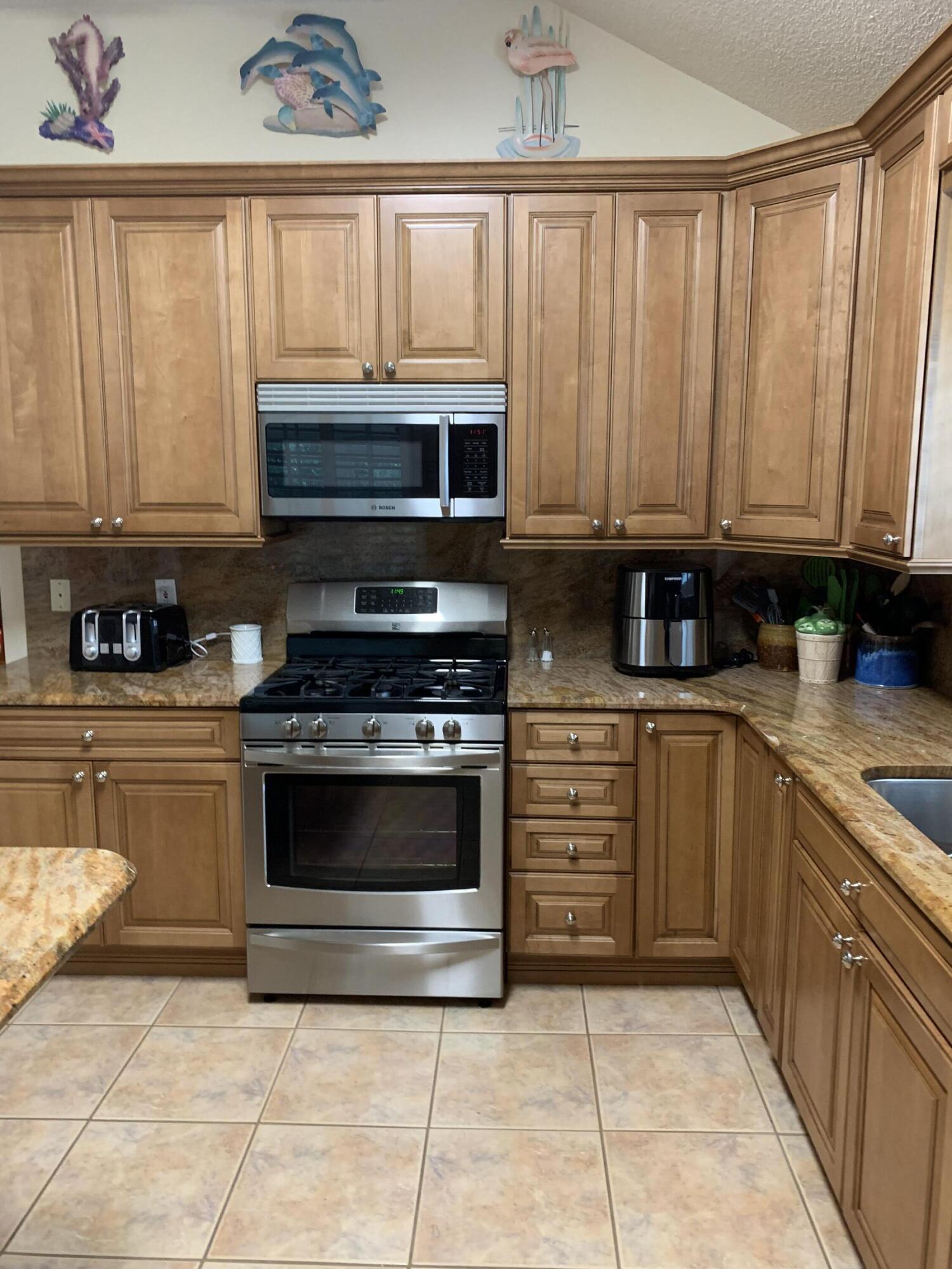 204 Bay Tree Drive Miramar Beach, FL 32550 - Photo 4 of 11 a kitchen with granite countertop a stove top oven microwave and cabinets
