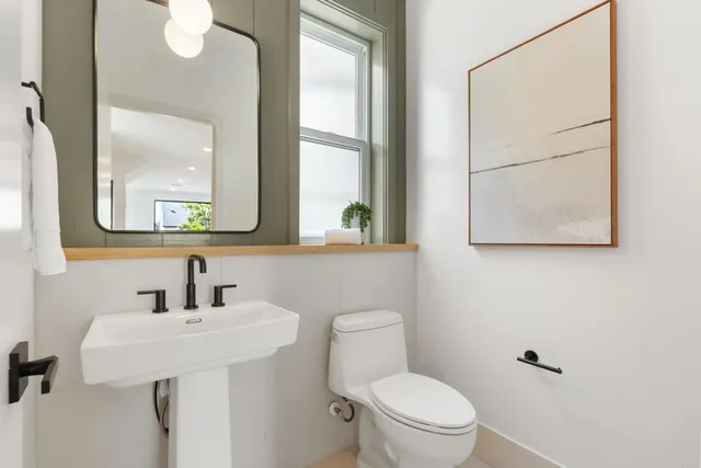 a bathroom with a toilet a sink and a mirror