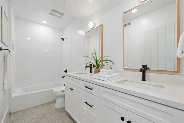 a bathroom with a granite countertop sink a toilet and a bathtub