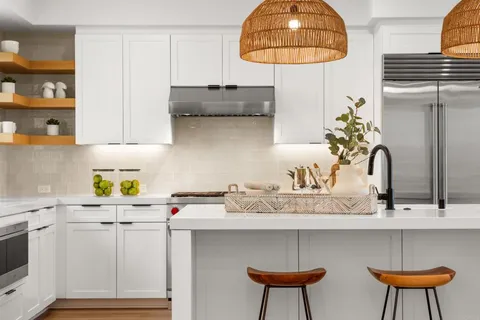 a kitchen with stainless steel appliances a table chairs and a wooden floor