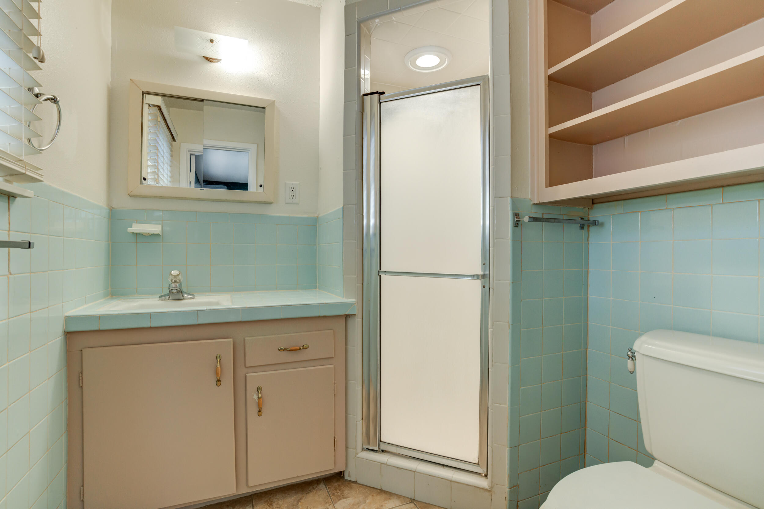 5403 8th Street Lubbock, TX 79416 - Photo 13 of 30 a bathroom with a toilet a sink and mirror