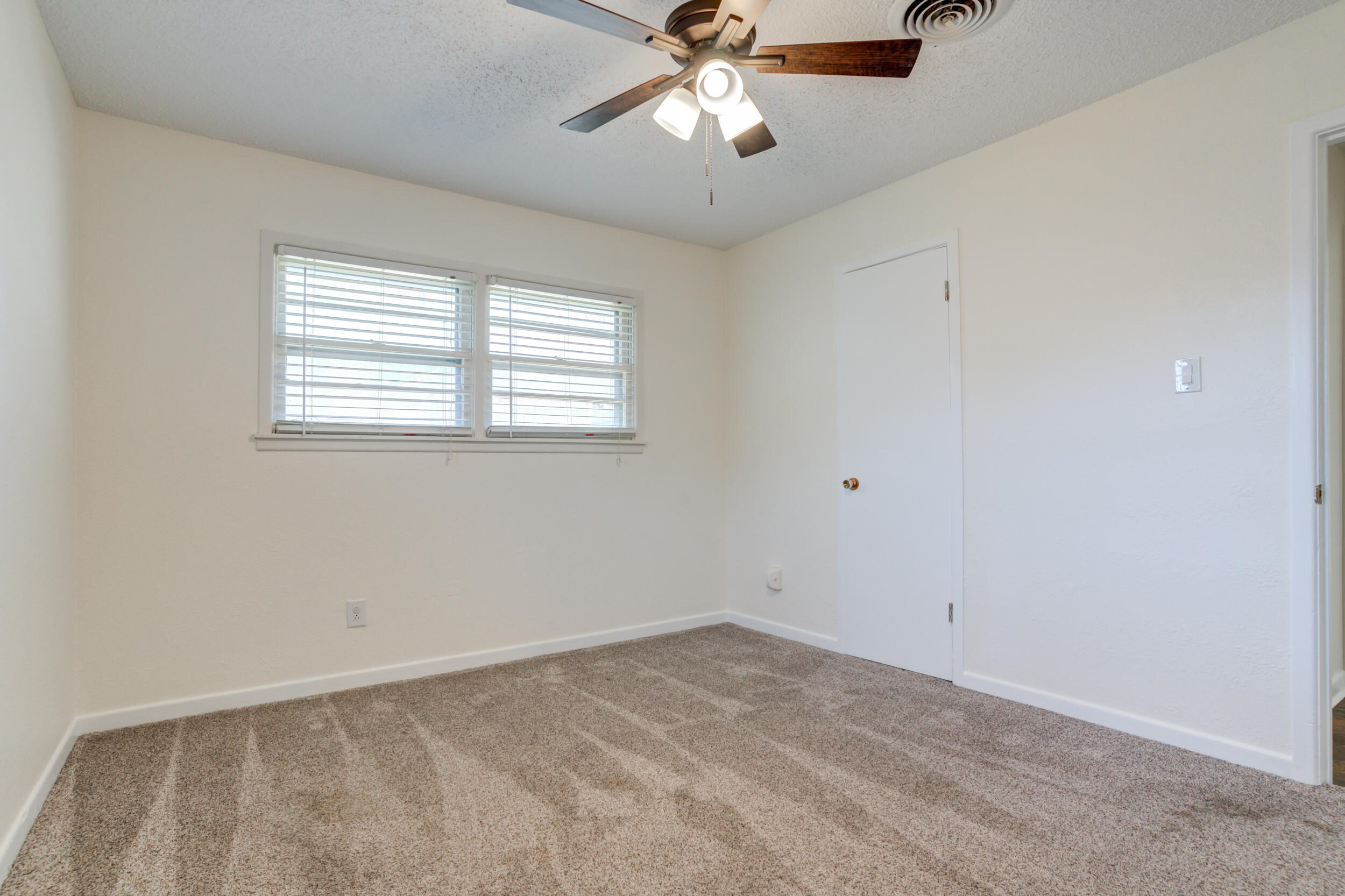 5403 8th Street Lubbock, TX 79416 - Photo 15 of 30 an empty room with a window and a chandelier fan
