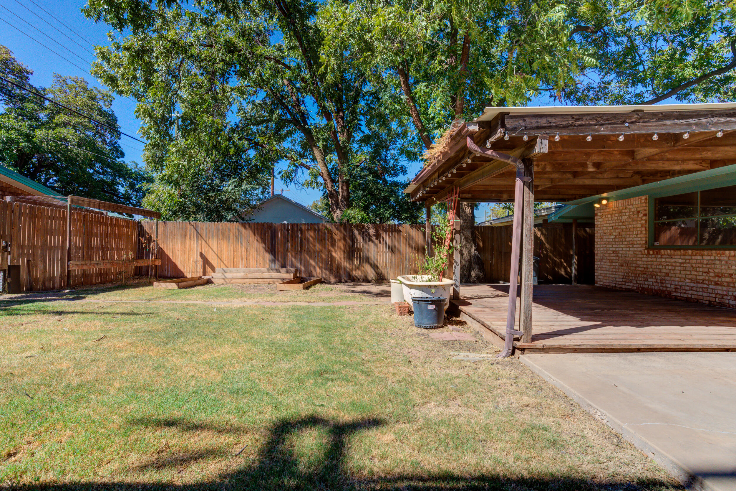 5403 8th Street Lubbock, TX 79416 - Photo 28 of 30 a view of a backyard with a table and chairs under an umbrella