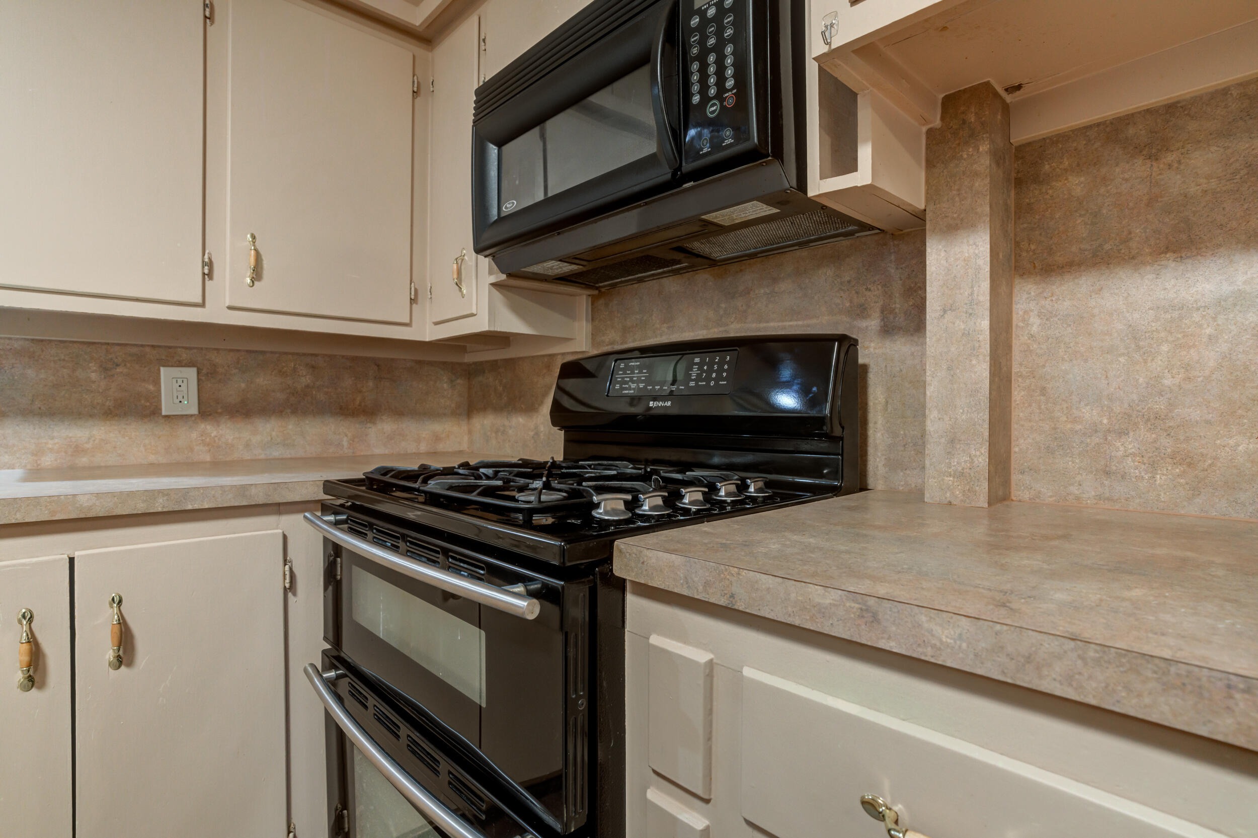5403 8th Street Lubbock, TX 79416 - Photo 9 of 30 a kitchen with granite countertop white cabinets stainless steel appliances and a counter space