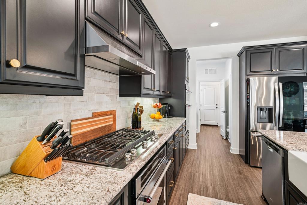 33294 Barmetta Lane Temecula, CA 92592 - Photo 11 of 36 a kitchen with stainless steel appliances granite countertop a refrigerator and a stove