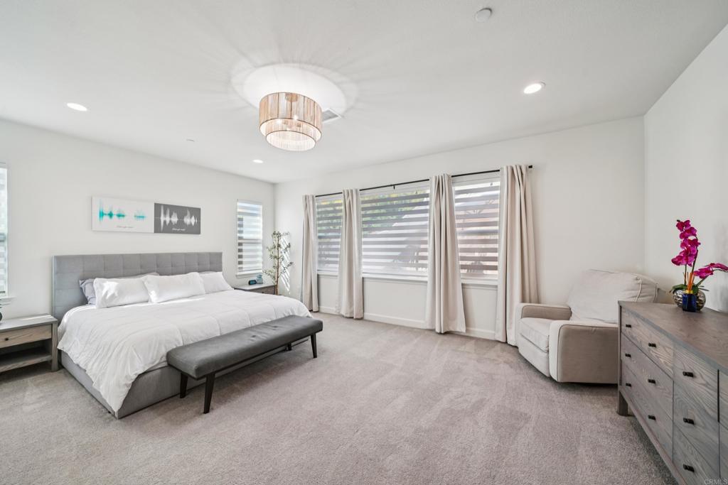 33294 Barmetta Lane Temecula, CA 92592 - Photo 15 of 36 a spacious bedroom with a bed and a chandelier