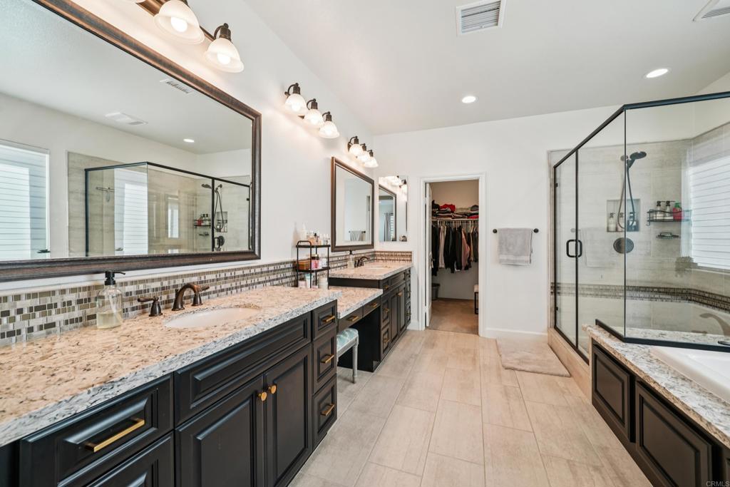 33294 Barmetta Lane Temecula, CA 92592 - Photo 17 of 36 a spacious bathroom with a granite countertop double vanity sink a mirror and a shower
